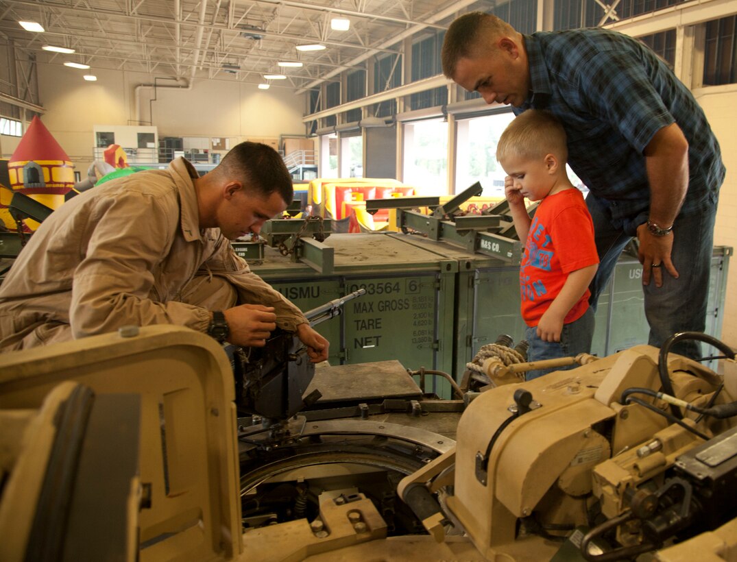 PFC Nicholas Matteson, a tank crewman with 2nd Tank Battalion, shows a father and son what the inside of a M1A1 tank looks like during a family day aboard Marine Corps Base Camp Lejeune, Aug. 16.  The event featured bouncy houses, refreshments as well as different military vehicles for the families to view. Capt. Heather Ichord, a logistics officer with 2nd Tank Battalion, said family days are important because it allows the Marines to slow down and appreciate their families and all that they do to support them.
Find us on Google + (http://gplus.to/camp.lejeune)
Follow us on Twitter (http://twitter.com/camp_lejeune)
Like us on Facebook (http://www.facebook.com/camp.lejeune)
