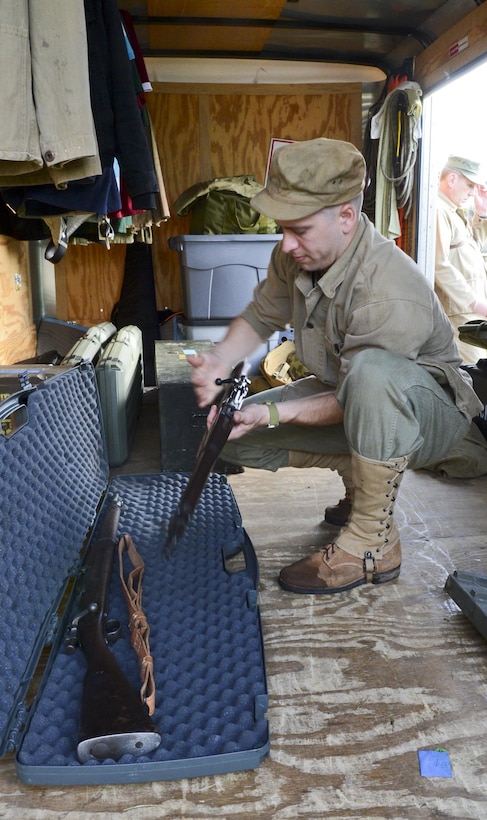 Thomas Frezza, logistic support for the United States Marine Corps Historical Company, prepares to issue weapons to volunteers for a tactical demonstration at the Virginia Museum of Military Vehicles on Aug. 17, 2013. The volunteers donned World War II era Marine uniforms and weapons and engaged a fixed position. 
