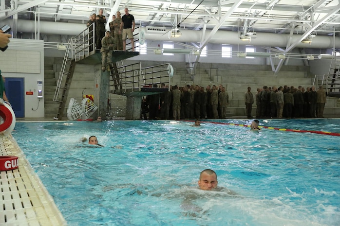 Recruits of Company C, 1st Recruit Training Battalion, jump off a 10-foot tower using the abandon ship technique during Swim Week aboard Marine Corps Recruit Depot San Diego, Aug. 19. Recruits are required to jump off and swim 25 meters to safety.