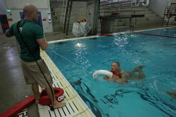 Sgt. Eric I. Pressman, Marine Combat Instructor Trainer of Water Survival, Instructional Training Company, Support Battalion, removes a recruit from the pool during Swim Week aboard Marine Corps Recruit Depot San Diego, Aug. 19. Recruits are removed from the pool if they fail to complete an event with proper technique or for safety reasons.