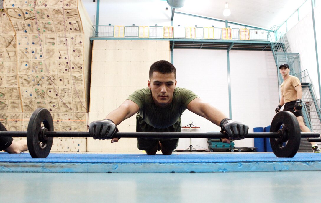 Lance Cpl. Francisco Deleon, radio technician, Lima Company, 3rd Battalion, 3rd Marine Regiment, Marine Rotation Force - Darwin, completes a barbell abdominal rollout during a Combat Fitness Leadership Course physical training session taught by students at the Northern Gym, here, Aug. 20. The course teaches students to lead physical training techniques. Two MRF-D Marines are attending the month-long course. This is the first time Marines have participated in an Australian Army training course here.