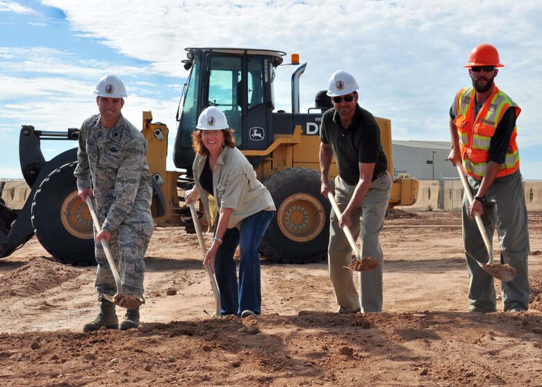 DAVIS-MONTHAN AFB, Ariz. – (From left to right) Lt. Col. Phil Acquaro, 42nd Electronic Combat Squadron commander; Michele Mickle, quality assurance representative in the U.S. Army Corps of Engineers Los Angeles District’s Tucson Resident Office; Tony Gomez, 355th Civil Engineer Squadron lead architect; and Andrew Erquiaga, RSCI Group construction team lead, toss ceremonial shovels of dirt for the new EC-130H Simulator Training Operations Facility during a groundbreaking ceremony held Aug. 15 at Davis-Monthan Air Force Base. When it is complete in August 2014, the new facility will provide space for new EC-130H flight deck simulator, new EC-130H mission crew simulator and one relocated EC-130H mission crew simulator among its many benefits.