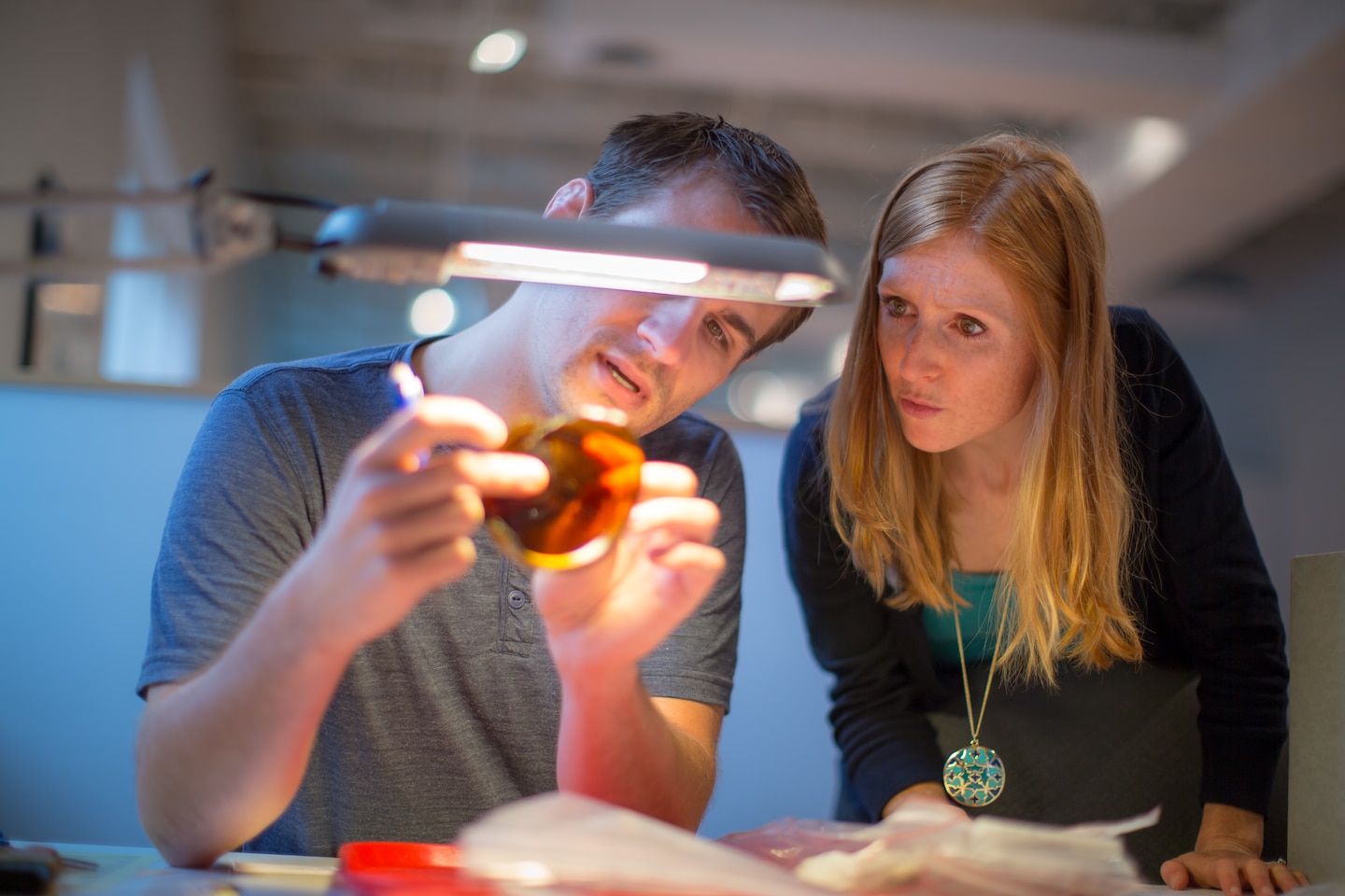 Lab Technician Jake Petrie (left) examines an artifact with Laboratory Manager Jasmine Heckman. 
