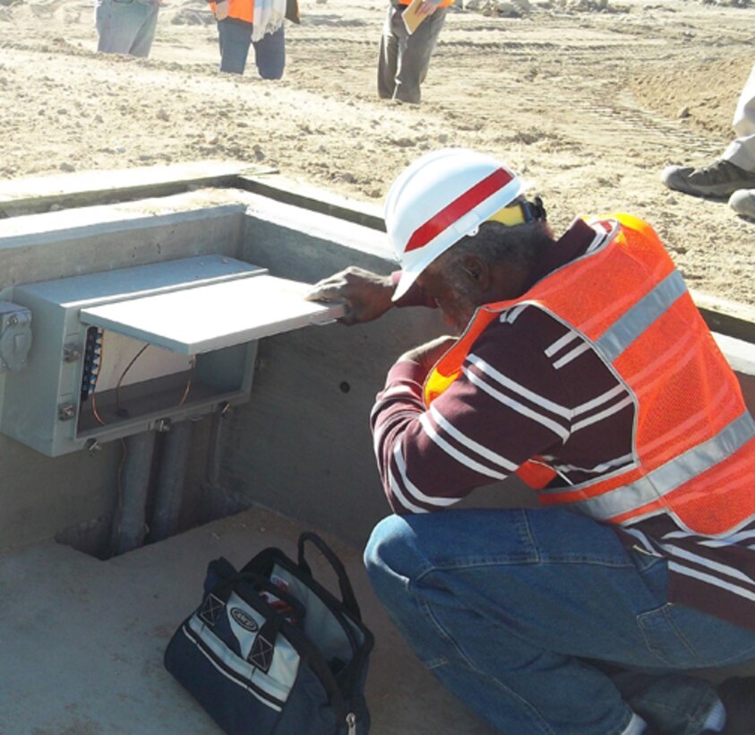 Huntsville Center electrical engineer William Strong, kneeling, performs a Construction Compliance Inspection at a Qualification Training Range on Fort Irwin, Calif., in January. The Army has tasked the organization’s Range Training and Land Program to perform two mandatory inspections on new range construction before completion.