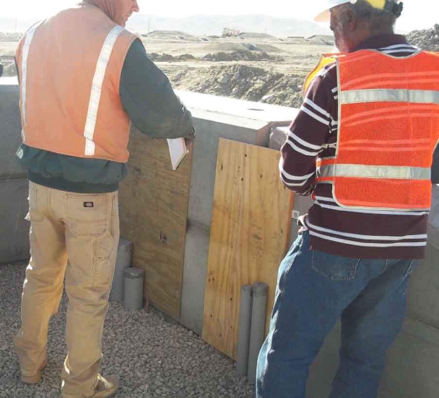 Huntsville Center electrical engineer William Strong, kneeling, performs a Construction Compliance Inspection at a Qualification Training Range on Fort Irwin, Calif., in January. The Army has tasked the organization’s Range Training and Land Program to perform two mandatory inspections on new range construction before completion.