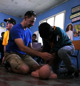 U.S. Army First Sgt. Sean Whitehead, Joint Task Force-Bravo’s Medical Elements first sergeant, teaches a Honduran Scout how to properly administer first aid at a local school in Comayagua, Aug. 17, 2013.  MEDEL is helping the Scouts learn first aid, so they can earn their first aid merit badge. 