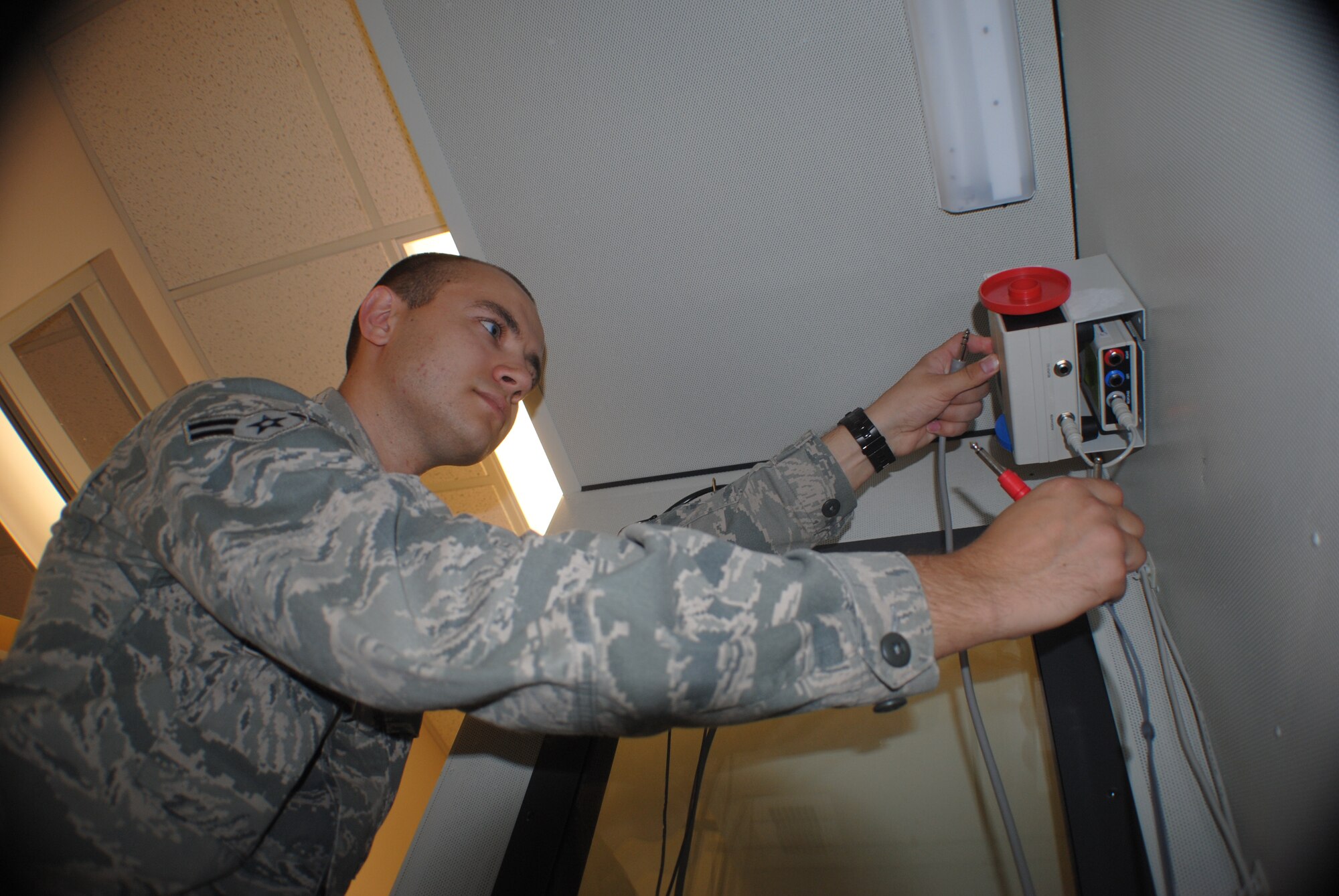 Airman 1st Class Morgan Hassig calibrates the testing devices inside a sound booth used to check a patient’s hearing ability Aug. 14, 2013, at the medical clinic on Grand Forks Air Force Base, N.D.  Hassig was named the base’s Warrior of the Week for Aug. 21-27, 2013.  (U.S. Air Force photo/Staff Sgt. Luis Loza Gutierrez) 