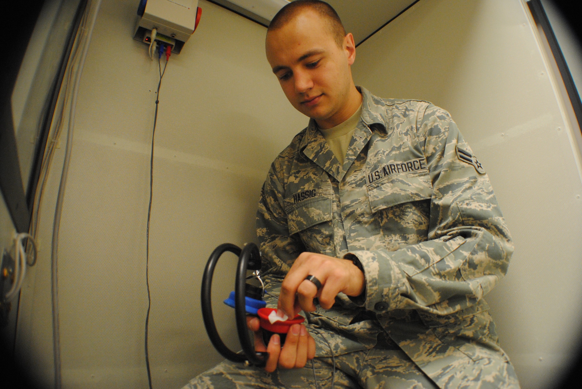 Airman 1st Class Morgan Hassig sanitizes a set of headphones inside a sound booth used to check a patient’s hearing ability Aug. 14, 2013, at the medical clinic on Grand Forks Air Force Base, N.D.  Hassig was named the base’s Warrior of the Week for Aug. 21-27, 2013. (U.S. Air Force photo/Staff Sgt. Luis Loza Gutierrez) 

