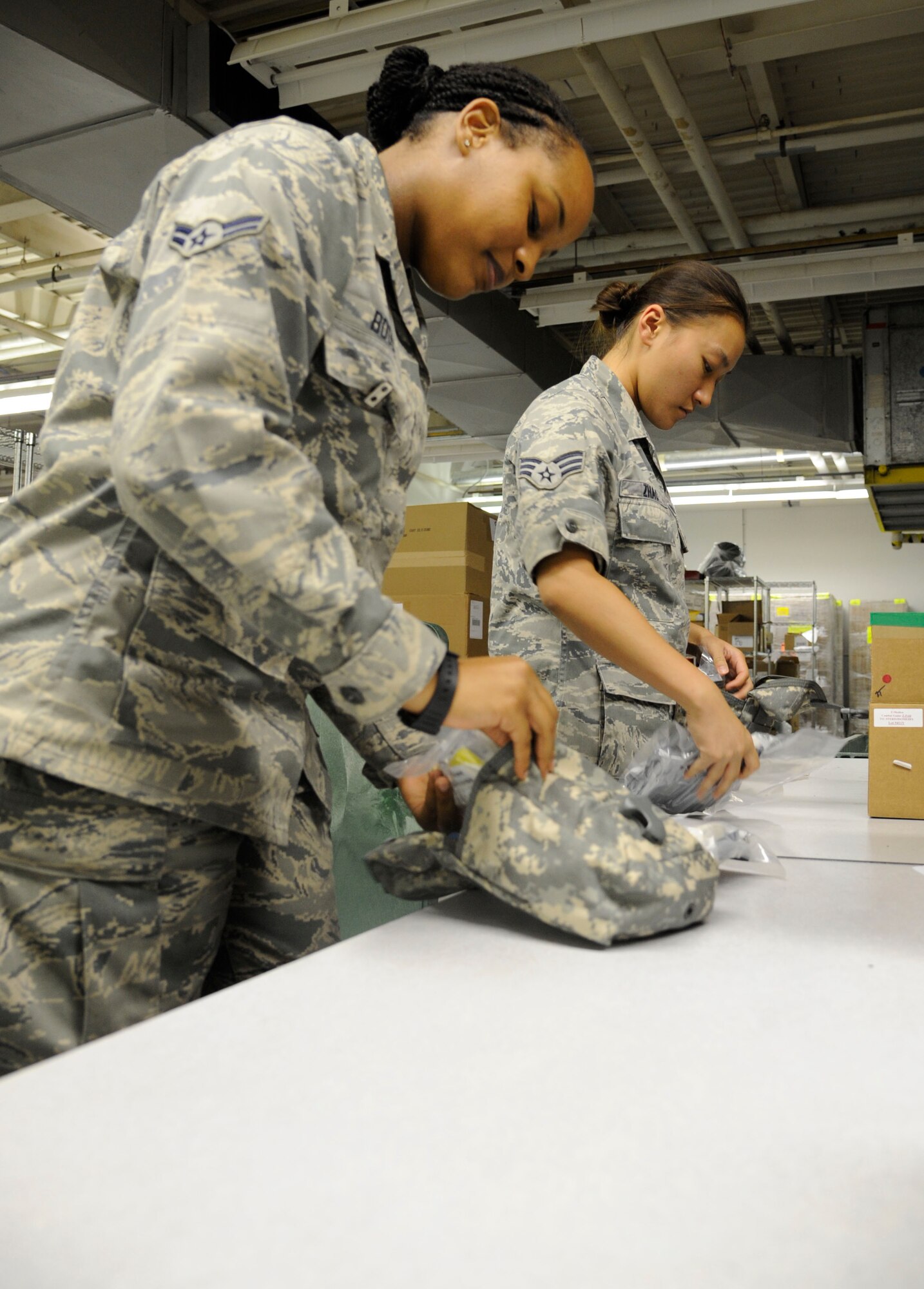 Airman 1st Class Alyssa Boose, left, and Senior Airman Evalin Zhao, 2nd Medical Support Squadron medical logistics technicians, pack individual first-aid kits on Barksdale Air Force Base, La., Aug. 21, 2013. IFAKs are given out to Airmen who are preparing to deploy and include items such as gauze and tourniquets. (U.S. Air Force photo/Airman 1st Class Andrew Moua)