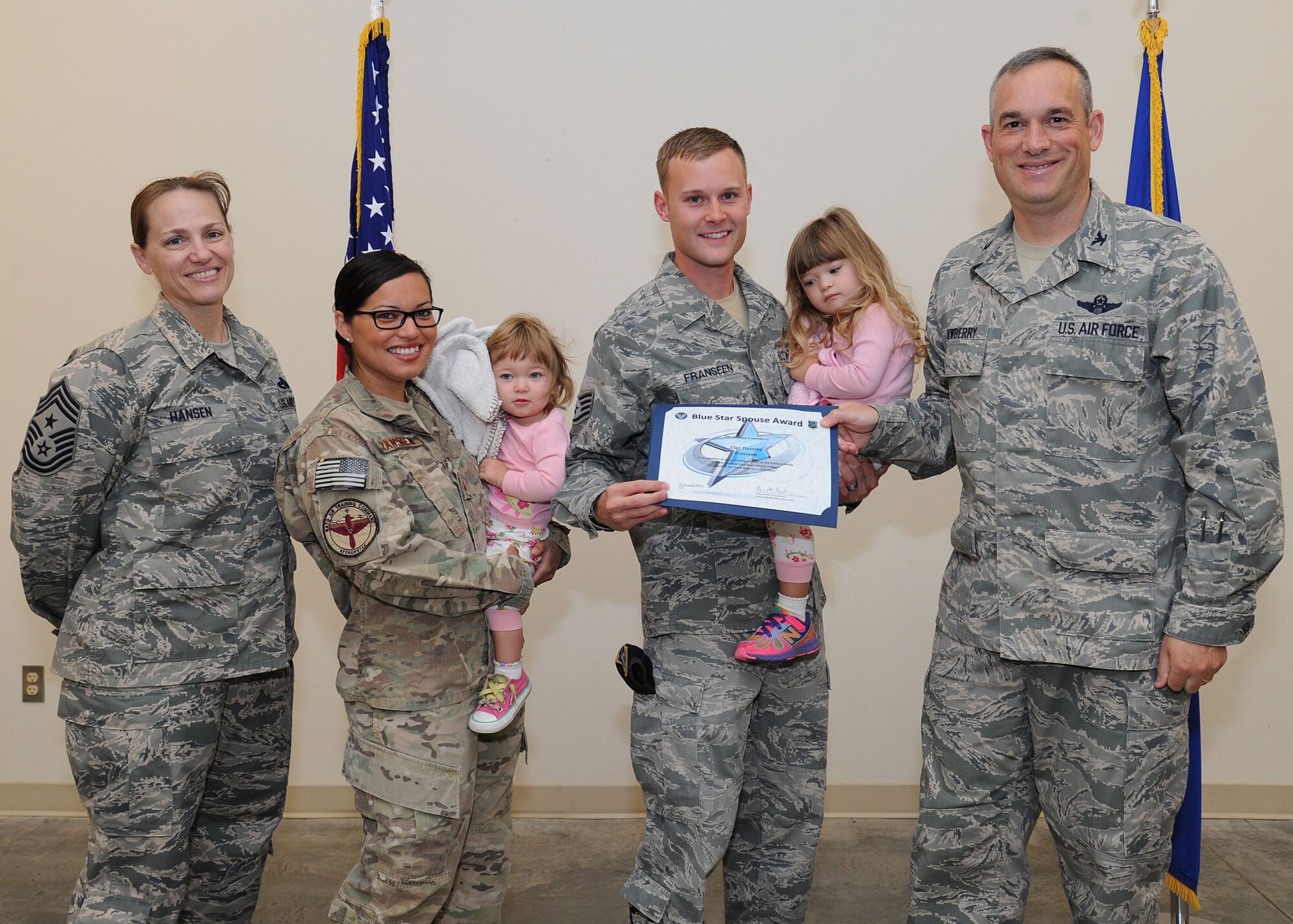 Col. Brian Newberry, 92nd Air Refueling Wing commander, and Chief Master Sgt. Wendy Hansen, 92nd ARW command chief, present the Blue Star Spouse Award to Staff Sgt. Timothy Franseen, 92nd Security Forces Squadron unit scheduling monitor, at Fairchild Air Force Base, Wash., Aug. 21, 2013. Franseen was presented the award  for his support of his two daughters while his wife, Tech. Sgt. Vanessa Franseen, 92nd Force Support Squadron career development section chief, was deployed for 6 months overseas. Anyone interested in nominating someone for the Blue Star Spouse Award should contact their squadron commander. (U.S. Air Force photo by Airman 1st Class Janelle Patiño/Released)