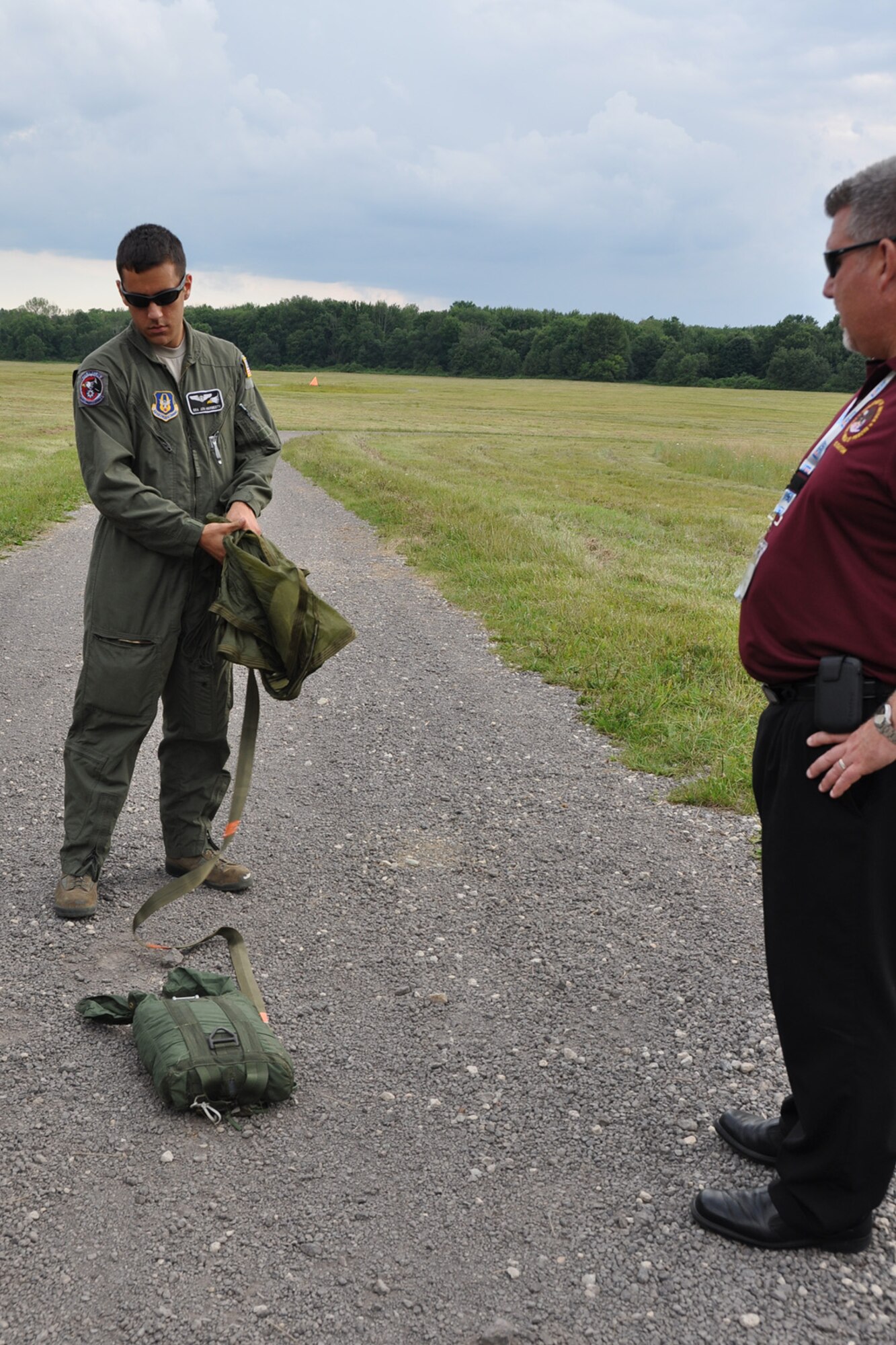 CAMP RAVENNA, Ohio – Air Force Reserve Senior Airman John Hardesty, a loadmaster assigned to the 910th Airlift Wing’s 757th Airlift Squadron, shows a parachute and weighted drop bundle to an employer at the Slagle Drop Zone here, August 1, 2013. The employer attended the inaugural Joint Employer Awareness Event, co-hosted by the 910th, the Ohio National Guard and Ohio Employer Support of the Guard and Reserve (ESGR). The two-day event gave employers of Air Force Reservists and Guardsmen the opportunity to get an up-close look at both Camp Ravenna and YARS. The event also gave the employers a better understanding of the mission that their employees carry out as members of the U.S. Armed Forces. U.S. Air Force photo by Master Sgt. Bob Barko Jr.