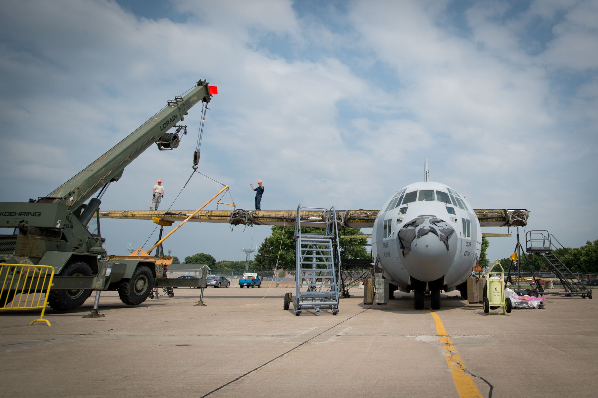 Members of the 402nd Expeditionary Maintenance Group work to remove the wings and dismantle a retired C-130 aircraft at Minneapolis-St. Paul Air Reserve Station, Minn.  (U.S. Air Force photo/Keith Langsdorf)