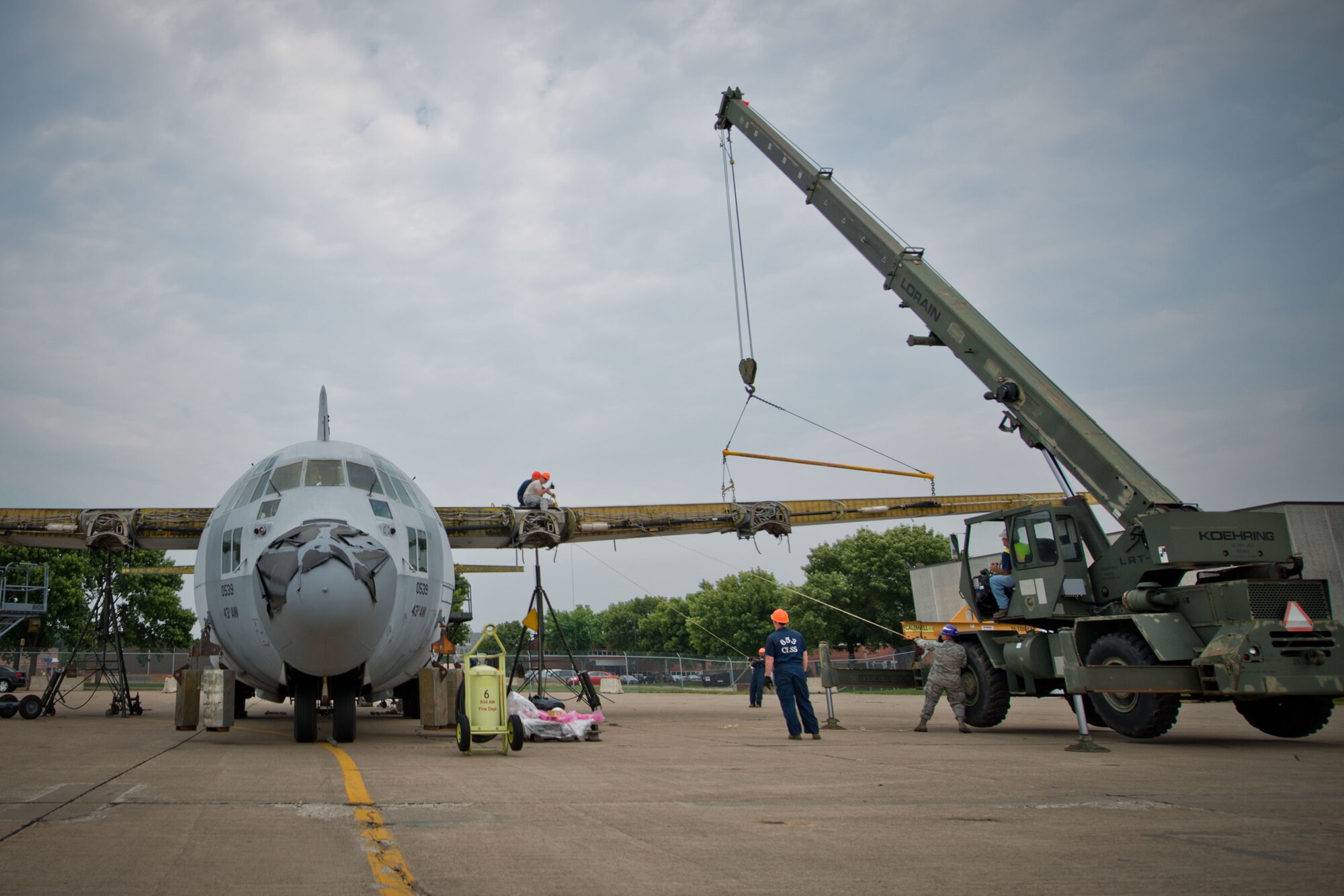 Members of the 402nd Expeditionary Maintenance Group work to remove the wings and dismantle a retired C-130 aircraft at Minneapolis-St. Paul Air Reserve Station, Minn.  (U.S. Air Force photo/Keith Langsdorf)