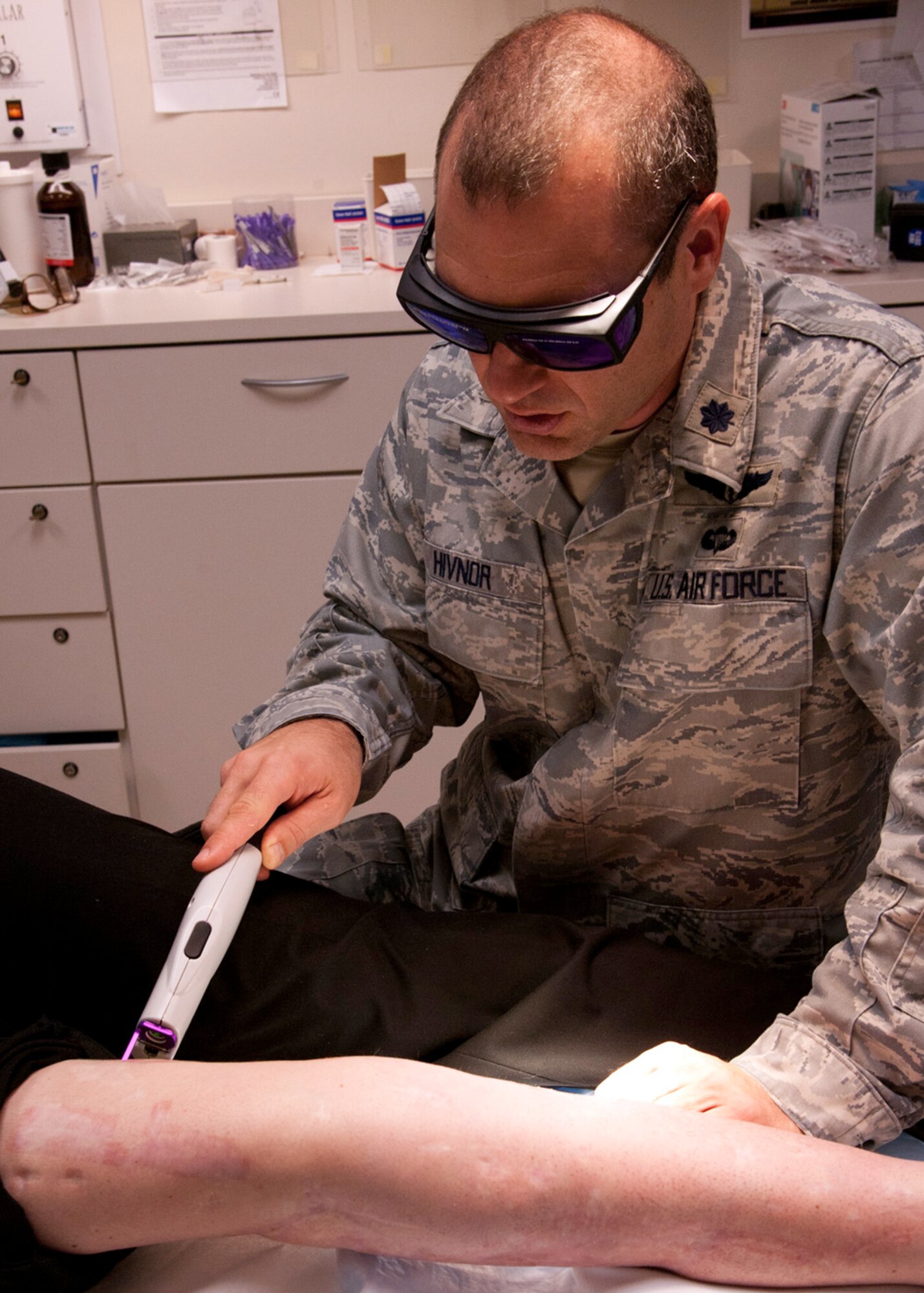 Lt. Col. Chad Hivnor uses a pulsed dye laser to help decrease redness on a wounded warrior’s scarred leg in the Dermatology Clinic at Wilford Hall Ambulatory Surgical Center, Joint Base San Antonio-Lackland, Texas Aug 7. Hivnor will receive the 2013 Paul W. Myers Award for his work using lasers to improve the skin texture and flexibility on wounded warriors. (U.S. Air Force photo/Senior Airman Courtney Moses)