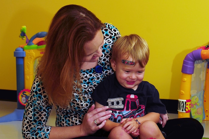 Rebecca Avey, 628th Medical Group Teddy's Child Watch trainer, plays with one year old Maxwell Shaw, son of Tech. Sgt. Michael Shaw, 437th Aerial Port Squadron cargo processing supervisor, while Maxwell's mom went to a medical appointment, Aug. 20, 2013 at JB Charleston- Air Base, S.C. Teddy's Child Watch provides short-term staff supervision to well children ages six weeks through 11 years old. The purpose of Teddy's is to help alleviate the stress of parents and guardians trying to find child care during medical appointments. You can assure that their child's health, safety and well-being are protected. (U.S. Air Force photo/ Airman 1st Class Chacarra Neal)
