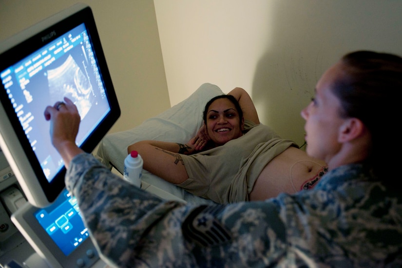 U.S. Air Force Tech. Sgt. Tamra Whiting, 633rd Surgical Operations Squadron ultrasound noncommissioned officer in charge, shows an ultrasound to U.S. Army Private 1st Class Samantha Soto, 359th Inland Cargo Transfer Company cargo specialist, during her appointment at Langley Air Force Base, Va., Aug. 15, 2013.  During an ultrasound, the technician measures various areas such as the head, umbilical cord and spine to guarantee the baby’s growth is on schedule with the gestation period. (U.S. Air Force photo by Staff Sgt. Stephanie Rubi/Released)