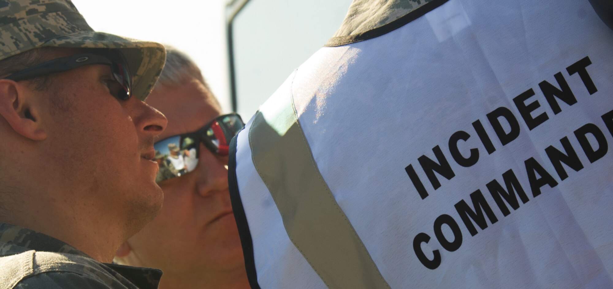 Liaisons from various base agencies speak with the incident commander during a field training exercise at Minot Air Force Base, N.D., Aug. 20, 2013. The purpose of the exercise was to evaluate and validate the integration and response of emergency management, security forces, fire department, medical and missile field operations during a natural disaster. (U.S. Air Force photo/Senior Airman Brittany Y. Auld)