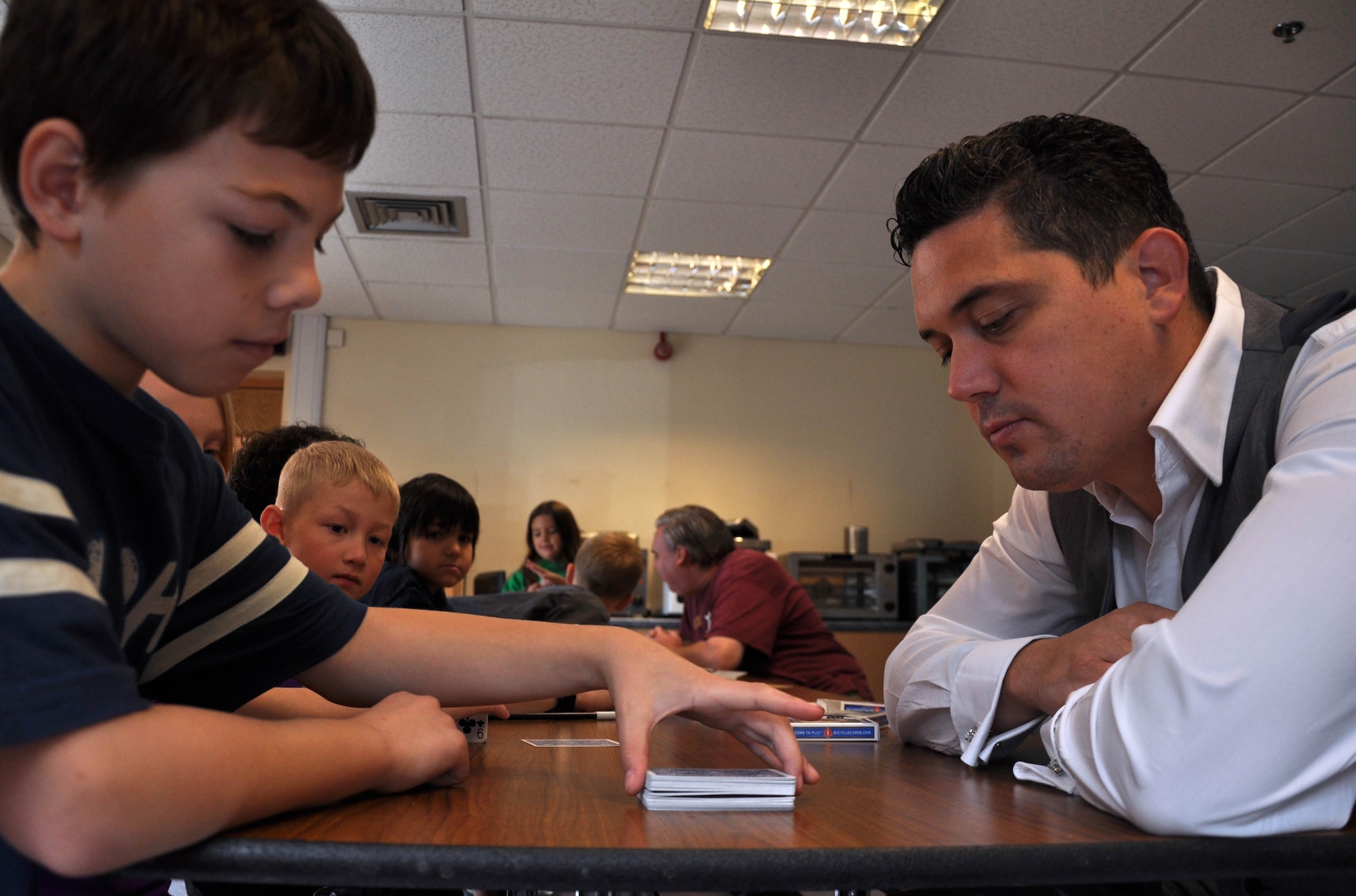 Michael J. Fitch, magician, teaches magic tricks to children Aug. 21, 2013, at the youth center on RAF Mildenhall, England. A three-day-long magic camp was one of the extra activities open for members of the RAF Mildenhall Youth Center. The camp takes the first two days to teach children magic tricks and the last day hosts a magic show. (U.S. Air Force photo by Rebecca Grillo/Released) Editors Note: This photo was taken by the 100th Air Refueling Wing Public Affairs Youth Employment Skills intern. 