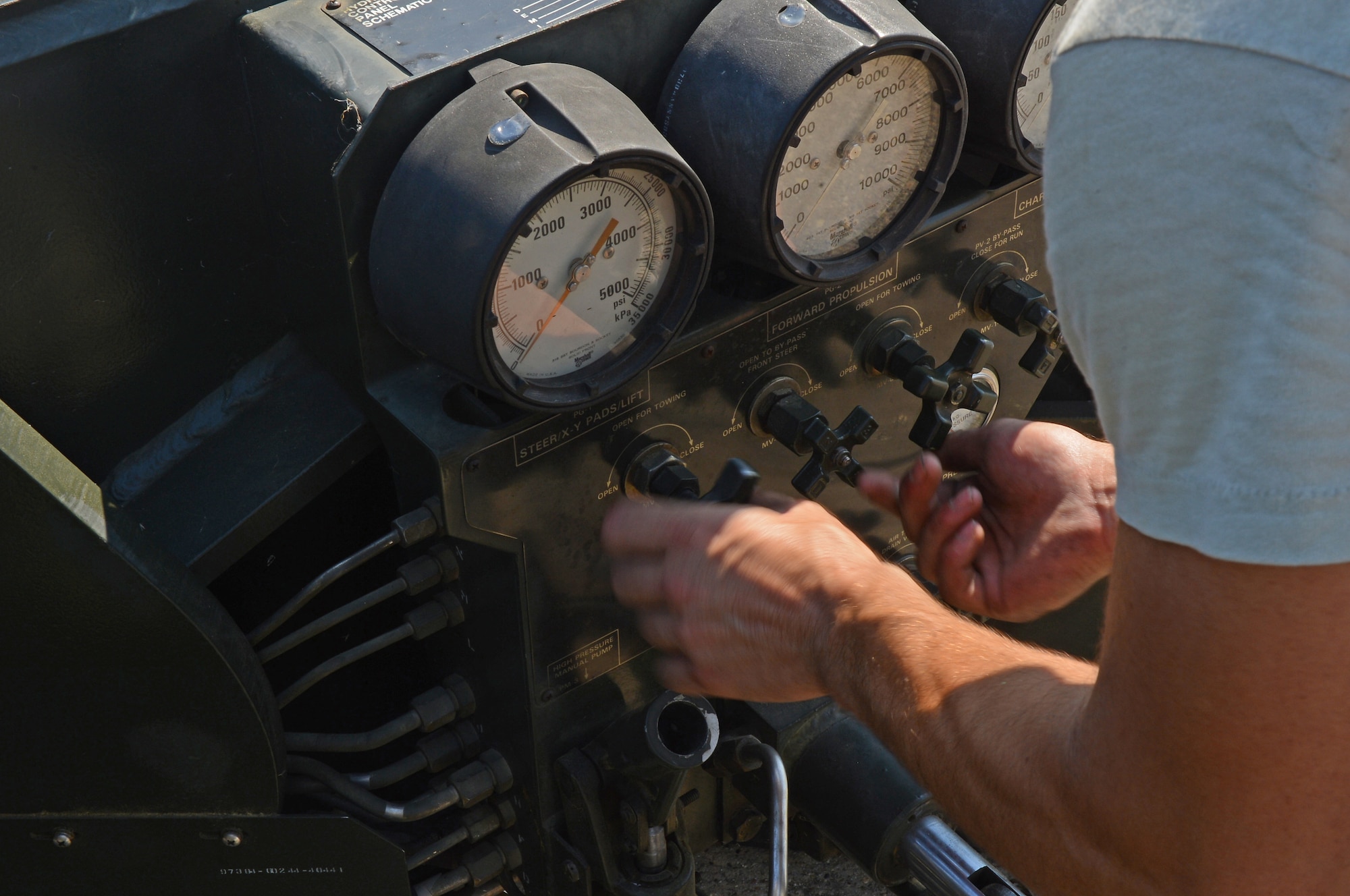 Senior Airman Matthew Fernandez, 2nd Maintenance Group weapons standardization crew member, turns nozzles on a strategic rotary launcher trailer on Barksdale Air Force Base, La., Aug. 20, 2013. In order for the trailer to be maneuvered by the load crew, certain nozzles have to be disengaged to take the trailer out of tow mode. (U.S. Air Force photo/Senior Airman Micaiah Anthony)
