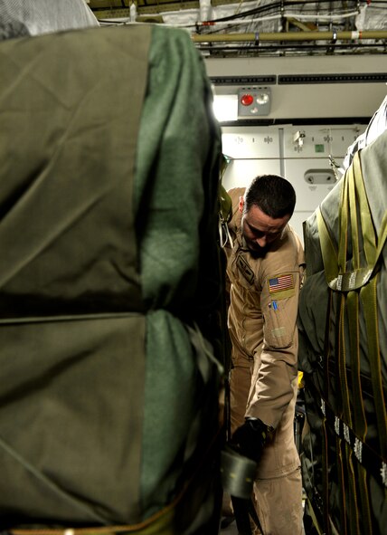 Staff Sgt. Chris Fullmer, 816th Air Expeditionary Squadron C-17 loadmaster, secures airdrop cargo prior to a mission departing from Bagram Airfield, Afghanistan, August 30, 2013. Fullmer is deployed from Charleston Air Force Base, S.C. (U.S. Air Force photo/ Staff Sgt. Stephenie Wade)