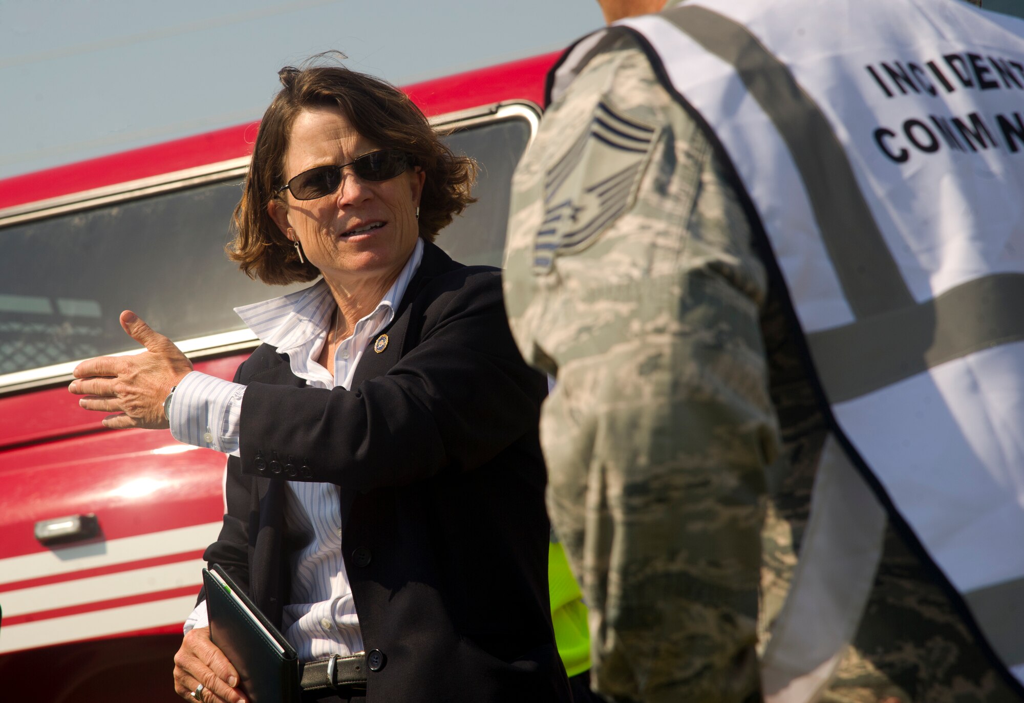 An agent from the Federal Bureau of Investigations speaks with the incident commander during a field training exercise at Minot Air Force Base, N.D., Aug. 20, 2013. The purpose of the exercise was to evaluate and validate the integration and response of emergency management, security forces, fire department, medical and missile field operations to an incident. (U.S. Air Force photo/Senior Airman Brittany Y. Auld)