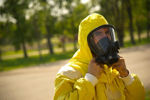 Staff Sgt. Haven Cherry, 5th Civil Engineer Squadron explosive ordnance disposal technician, dons his protective gear, during a field training exercise at Minot Air Force Base, N.D., Aug. 20, 2013. The purpose of the exercise was to evaluate and validate the integration and response of emergency management, security forces, fire department, medical and missile field operations to an incident. (U.S. Air Force photo/Senior Airman Brittany Y. Auld)