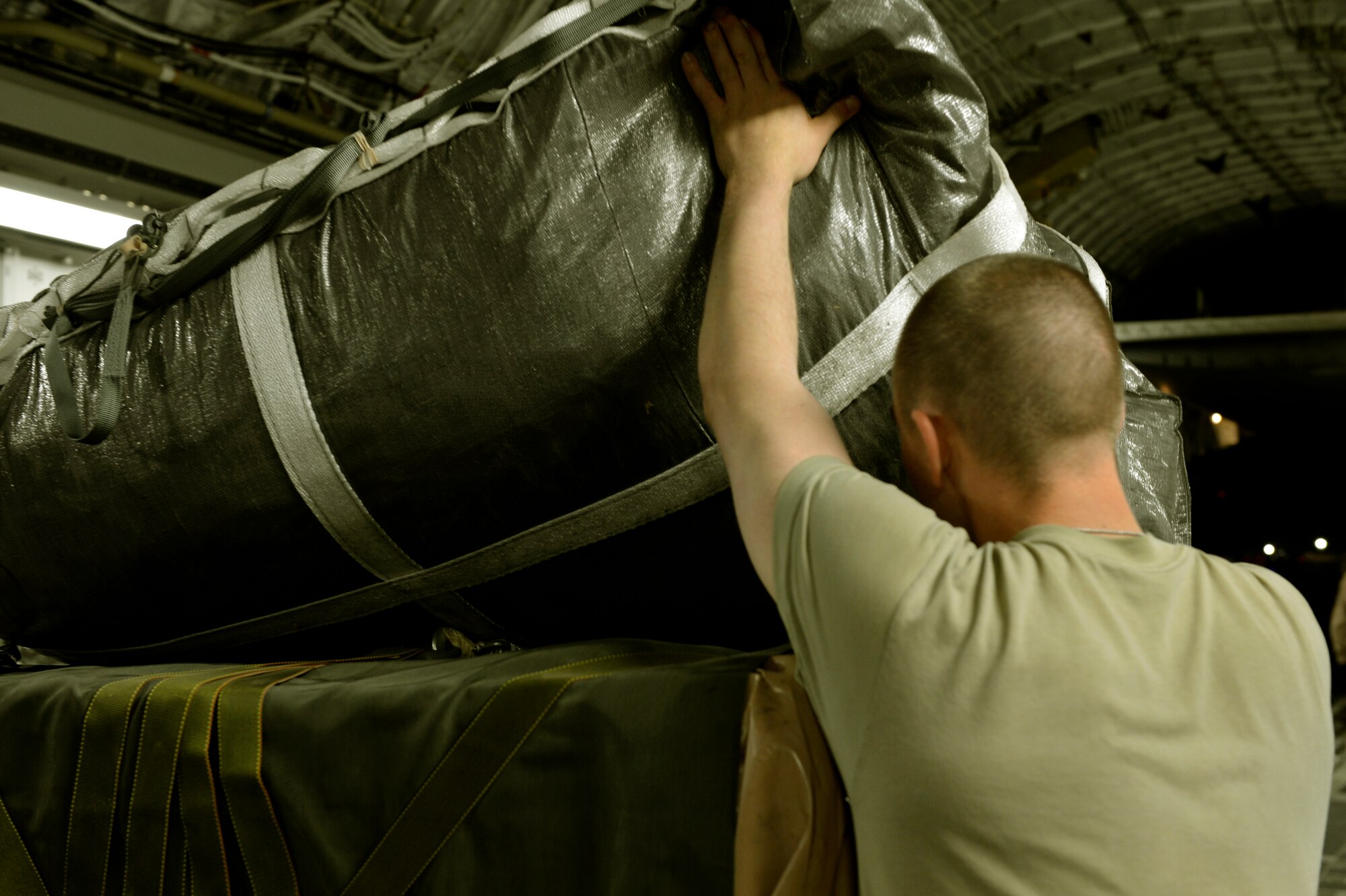 Staff Sgt. Kevin Johnson 455th Expeditionary Operations Support Squadron, NCO in charge of joint airdrop inspector’s office looks examines a parachute attached to an airdrop bundle on a C-17 on Bagram Airfield, Afghanistan, August 21, 2013. Johnson is one of two Airmen qualified to perform JAI inspections here. He is deployed from Joint Base Lewis-McChord, Wash., and a native of Wiesbaden, Germany.  (U.S. Air Force photo/ Staff Sgt. Stephenie Wade)