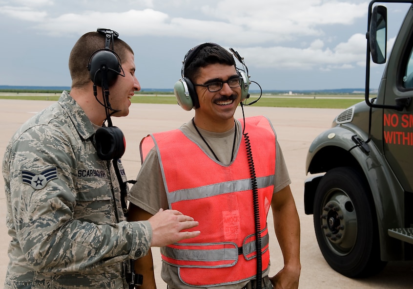U.S. Air Force Senior Airman Lance Scarbrough, 7th Logistics Readiness Squadron, Petroleum, Oils and Lubricants flight, left, speaks to Senior Airman Michael Alvarez, 7th Aircraft maintenance Squadron crew chief, Aug. 14, 2013, at Dyess Air Force Base, Texas. For his actions on July 19, when he provided self-aid buddy care to a seriously injured civilian worker, Scarbrough has been nominated for Air Combat Command’s ground safety award of distinction. (U.S. Air Force photo by Airman 1st Class Peter Thompson/Released)