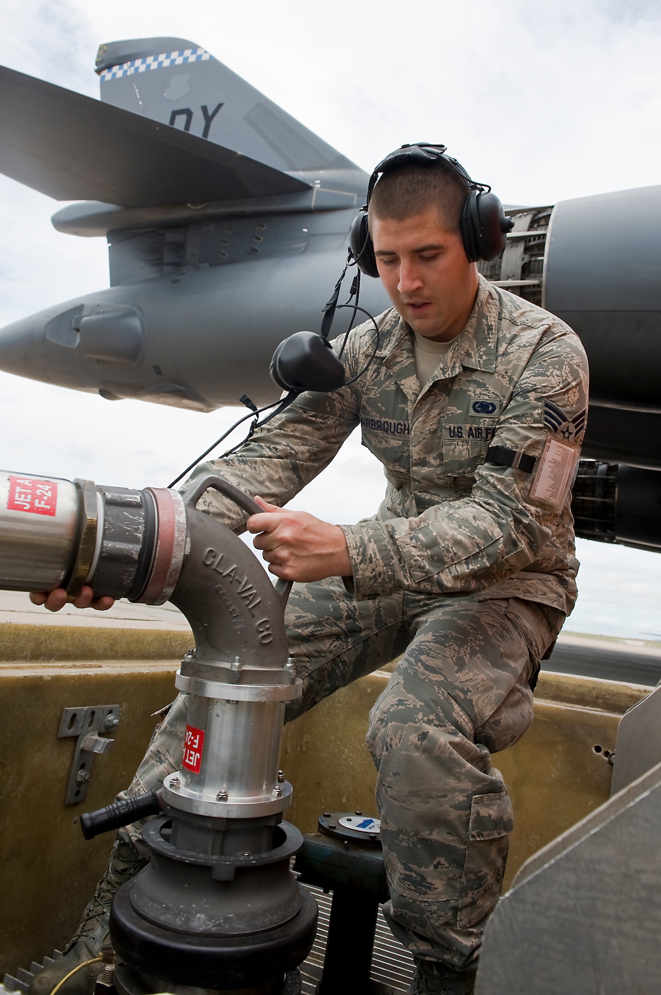 U.S. Air Force Senior Airman Lance Scarbrough, 7th Logistics Readiness Squadron, Petroleum, Oils and Lubricants flight, connects a moose head to a fuel pit prior to a hot-pit refuel Aug. 14, 2013, at Dyess Air Force Base, Texas. On July 19, while providing support to an outbound deploying aircraft, Scarbrough was the first to respond when a civilian employee fell from a maintenance stand onto his head and neck. (U.S. Air Force photo by Airman 1st Class Peter Thompson/Released)