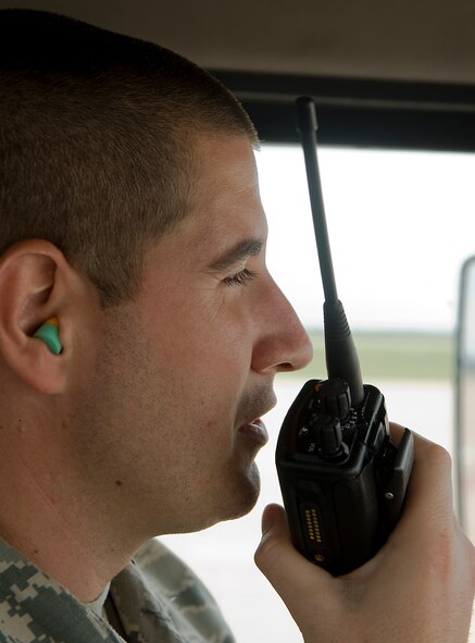 U.S. Air Force Senior Airman Lance Scarbrough, 7th Logistics Readiness Squadron, Petroleum, Oils and Lubricants flight, speaks with the POL control center on his radio Aug. 14, 2013, at Dyess Air Force Base, Texas. On July 19, while providing support to an outbound deploying aircraft, Scarbrough was the first to respond when a civilian employee fell from a maintenance stand onto his head and neck. (U.S. Air Force photo by Airman 1st Class Peter Thompson/Released)