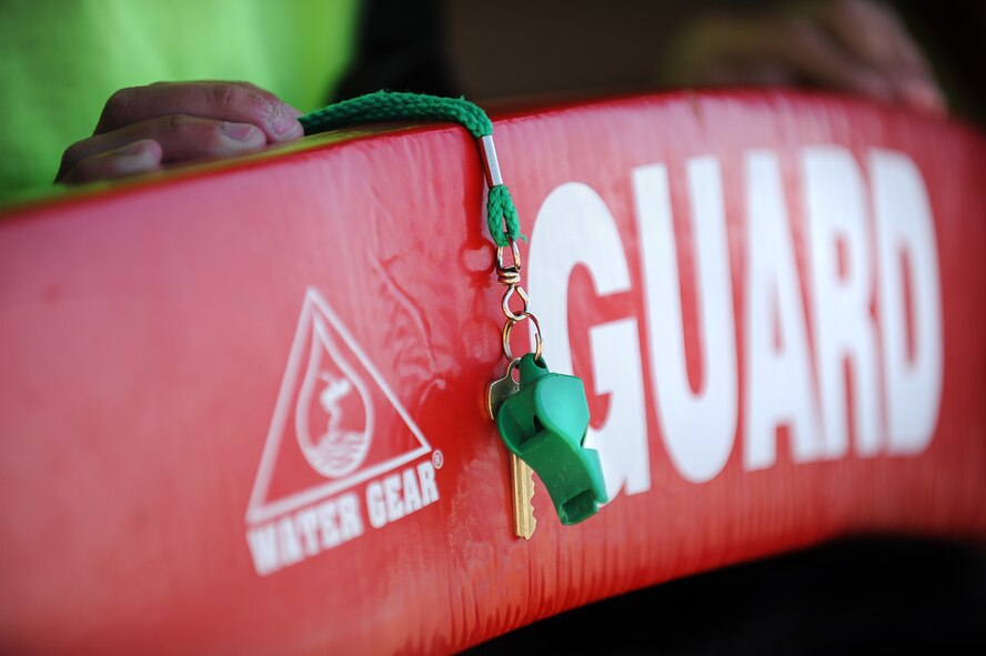 A life guard’s whistle and rescue device rest on the lap of an Outdoor Recreation life guard during swimming lessons at Minot Air Force Base, N.D., outdoor pool, Aug. 16, 2013. Swimming lessons have concluded for the summer, but will be picking up again in the winter at the indoor pool located in the McAdoo fitness center also located on base.  (U.S. Air Force photo/Airman 1st Class Stephanie Sauberan)