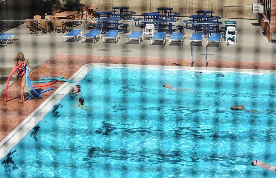 Megan Albers, Outdoor Recreation life guard, passes out flotation devices to swimming class participants during lessons at Minot Air Force Base, N.D., outdoor pool, Aug. 16, 2013. Swimming lessons have concluded for the summer, but are scheduled to resume in the winter at the indoor pool located in the McAdoo Sports and Fitness Center also located on base. (U.S. Air Force photo/Airman 1st Class Stephanie Sauberan)