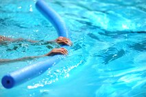 Savannah Hansford, daughter of Chief Master Sgt. Dewey Hansford, 91st Missile Security Forces Squadron security forces manager, practices swimming with a flotation device during lessons at Minot Air Force Base, N.D., outdoor pool, Aug. 16, 2013. Outdoor Recreation offers both summer and winter swimming classes the latter being held at the indoor pool located at the McAdoo fitness center also located on base. (U.S. Air Force photo/Airman 1st Class Stephanie Sauberan) 