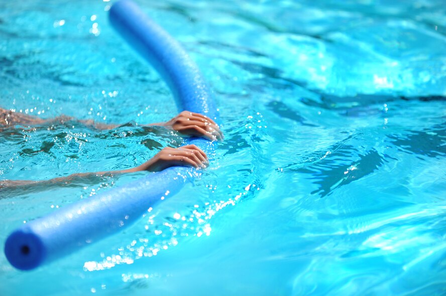 Savannah Hansford, daughter of Chief Master Sgt. Dewey Hansford, 91st Missile Security Forces Squadron security forces manager, practices swimming with a flotation device during lessons at Minot Air Force Base, N.D., outdoor pool, Aug. 16, 2013. Outdoor Recreation offers both summer and winter swimming classes the latter being held at the indoor pool located at the McAdoo fitness center also located on base. (U.S. Air Force photo/Airman 1st Class Stephanie Sauberan) 