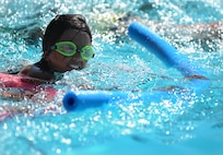 Savannah Hansford, daughter of Chief Master Sgt. Dewey Hansford, 91st Missile Security Forces Squadron security forces manager, practices swimming with a flotation device during lessons at Minot Air Force Base, N.D., outdoor pool, Aug. 16, 2013. Outdoor Recreation offers both summer and winter swimming classes, the latter being held at the indoor pool located at the McAdoo Sports and Fitness Center also located on base. (U.S. Air Force photo/Airman 1st Class Stephanie Sauberan) 