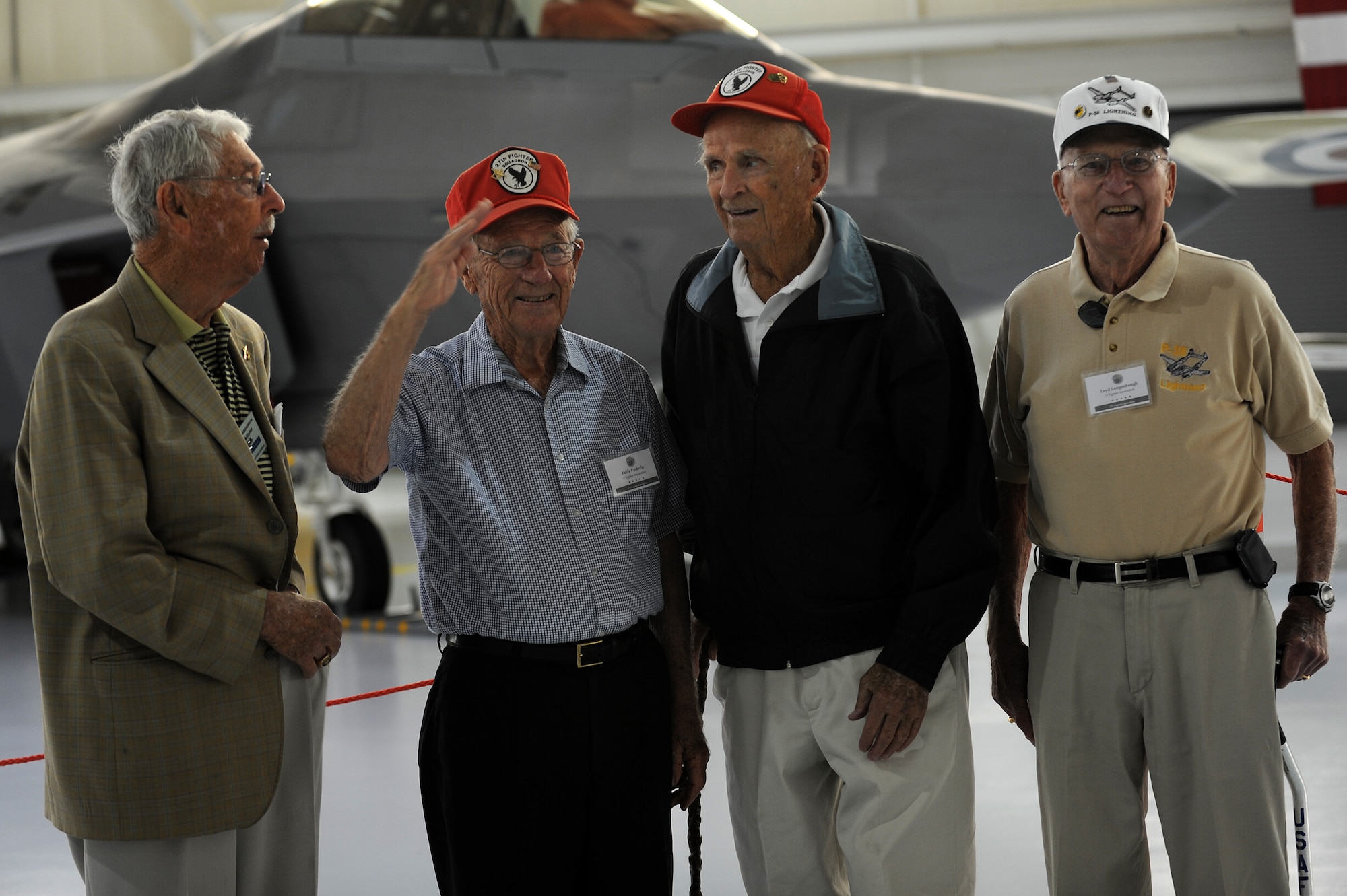 Prior World War II pilots pose in front of the F-22 Raptor while participating in a tour in part with the 1st Fighter Wing Association reunion at Langley Air Force Base, Va., Aug. 16, 2013. At the end of the tour, the group retired a flag created in Aug. of 1990 by 1st FW wives. (U.S. Air Force photo by Airman 1st Class Kimberly Nagle/Released) 