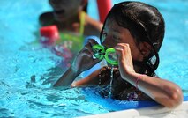 Savannah Hansford, daughter of Chief Master Sgt. Dewey Hansford, 91st Missile Security Forces Squadron security forces manager, adjusts her goggles during swimming lessons at Minot Air Force Base, N.D., outdoor pool, Aug. 16, 2013. Savannah practiced diving and swimming with a flotation device. (U.S. Air Force photo/Airman 1st Class Stephanie Sauberan)