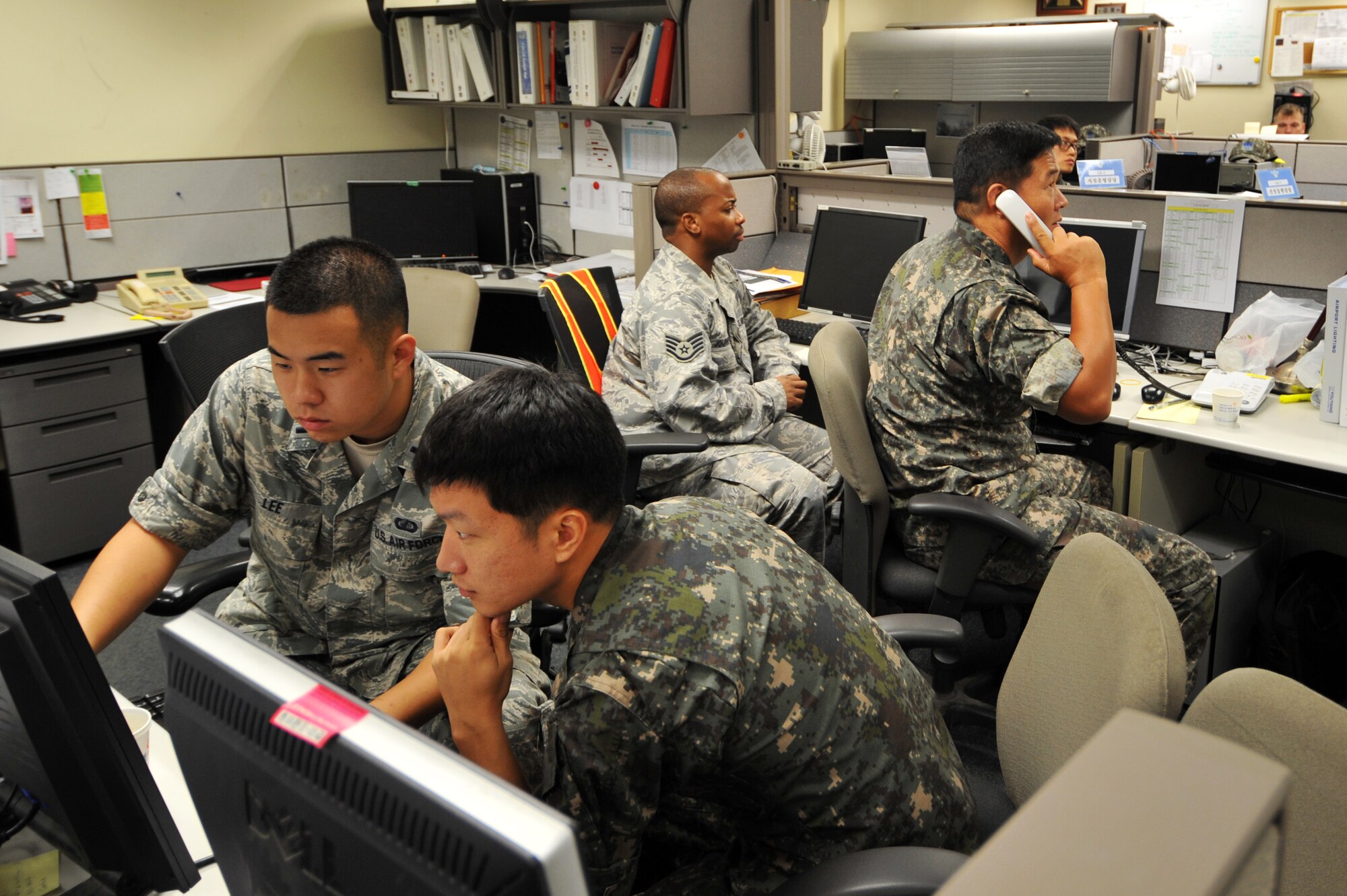 (Foreground) U.S. Air Force 1st Lt. Eric Lee, Air Component Command installations and mission support directorate contracting liaison officer (left) and Republic of Korea Air Force 1st Lt. Hyun Lee, a directorate interpreter, talk through an exercise scenario during Ulchi Freedom Guardian at Osan Air Base, ROK, Aug. 20, 2013. UFG, held annually, highlights the longstanding military partnership, commitment and enduring friendship between the two nations, help to ensure stability and security on the peninsula and reaffirm the United States’ commitment to the Northeast Asia region. (U.S. Air Force photo/Staff Sgt. Emerson Nuñez)