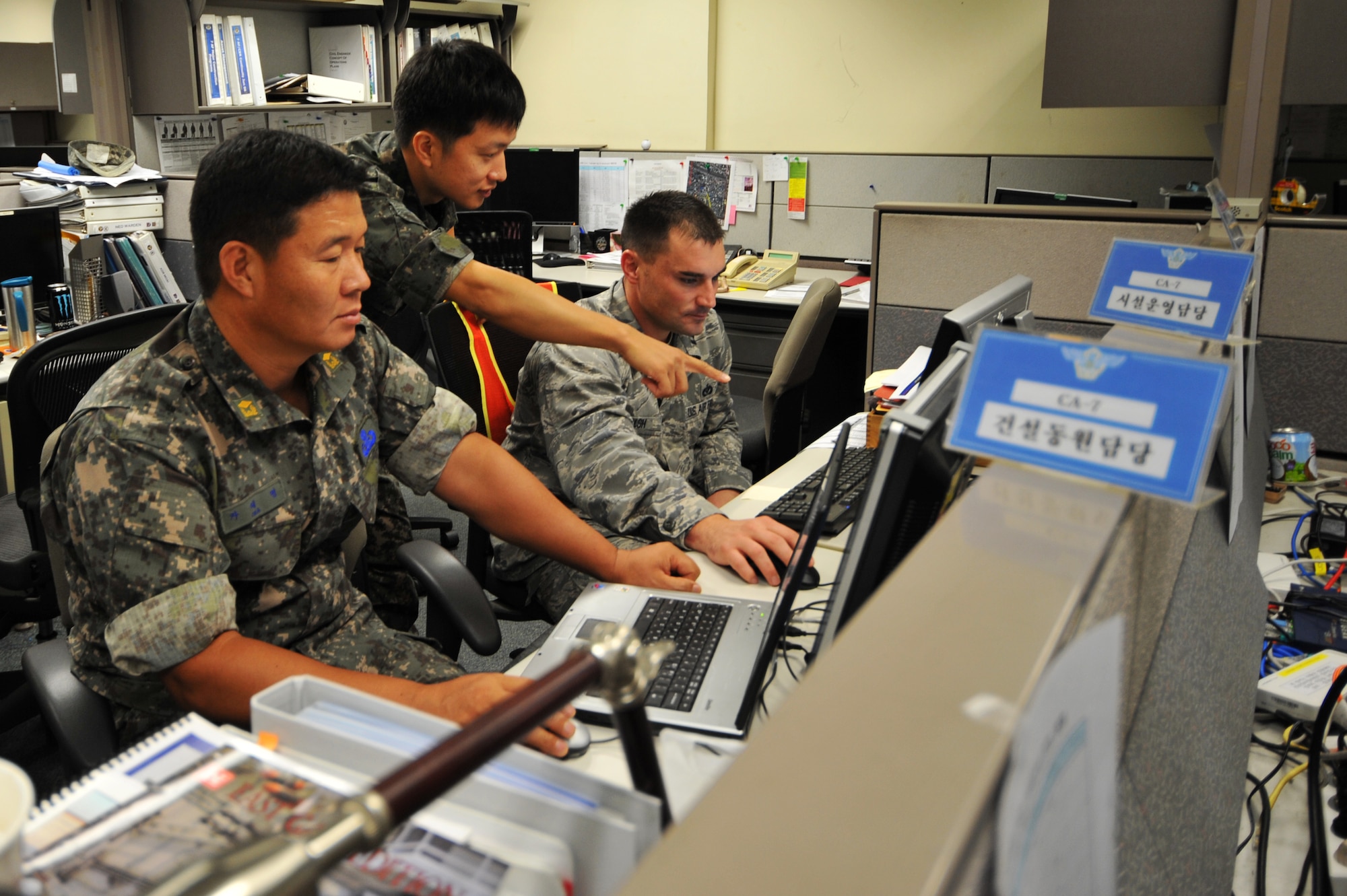 (Left to right) Republic of Korea Air Force Warrant Officer Cha Jae Myeong, and 1st Lt. Hyun Lee, talk with U.S. Air Force Capt. Jonathan Walsh, Air Component Command Installations and Mission Support Directorate chief of plans and exercises, during Ulchi Freedom Guardian 2013 at Osan Air Base, ROK, Aug. 20, 2013. Myeong is an explosive ordnance disposal representative and Lee is an interpreter within the installations and mission support directorate. Training exercises like UFG are carried out in the spirit of the Oct. 1, 1953, ROK-U.S. Mutual Defense Treaty and in accordance with the armistice. (U.S. Air Force photo/Staff Sgt. Emerson Nuñez)