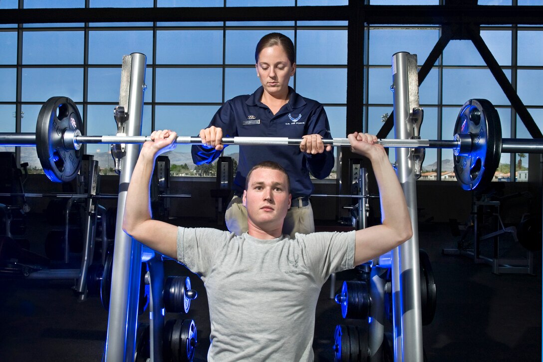 The military services are using innovative ways to preserve morale, welfare and recreation services and programs, particularly those such as fitness centers that directly impact military readiness. Here, Air Force Senior Airman Whitney Massey, 99th Force Support Squadron services journeyman, spots Airman 1st Class Benjamin Hurst on the free weights at the Warrior Fitness Center at Nellis Air Force Base, Nev. Air Force photo by Lawrence Crespo