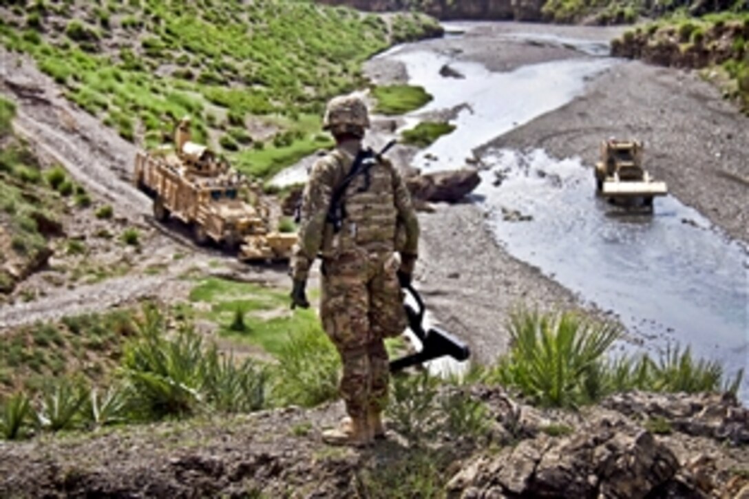 U.S. Army Sgt. Kenton D. Smith looks from above to check the progress of vehicles during a patrol to clear routes in Khowst province, Afghanistan, Aug. 14, 2013. Smith, a combat engineer, is assigned to the 101st Airborne Division's Company A, 4th Brigade Special Troops Battalion, 4th Brigade Combat Team.