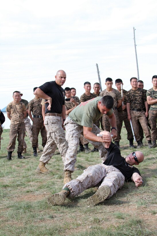 Marines with 3rd Law Enforcement Battalion demonstrate mechanical advantage control holds during the Nonlethal Weapons Executive Seminar 2013 Aug. 19 in Five Hills Training Area, Mongolia. NOLES is designed to promote awareness and effective use of nonlethal weapons as a tool to maintain order in low-intensity or civil unrest situations. 3rd LE Bn. is with III Marine Expeditionary Force Headquarters Group, III MEF. Photo by Sgt. John M. Ewald