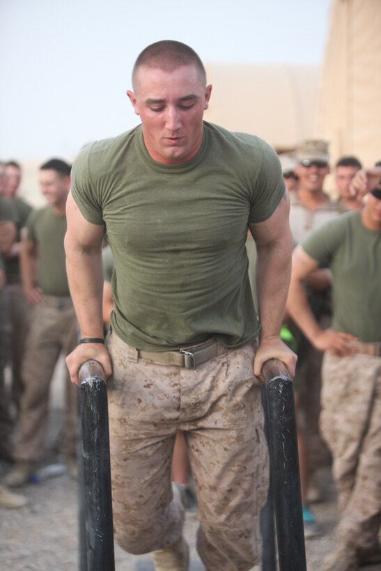 Lance Cpl. Brendan Hennessy, 19, a rifleman with Company E, 2nd Battalion, 8th Marine Regiment, Regimental Combat Team 7, performs dips as part of the strong man competition held July 23. "At the end of the day it's all about fitness and building camaraderie between Marines," said Hennessy. "Win or lose it was just for fun, and that's all that matters."