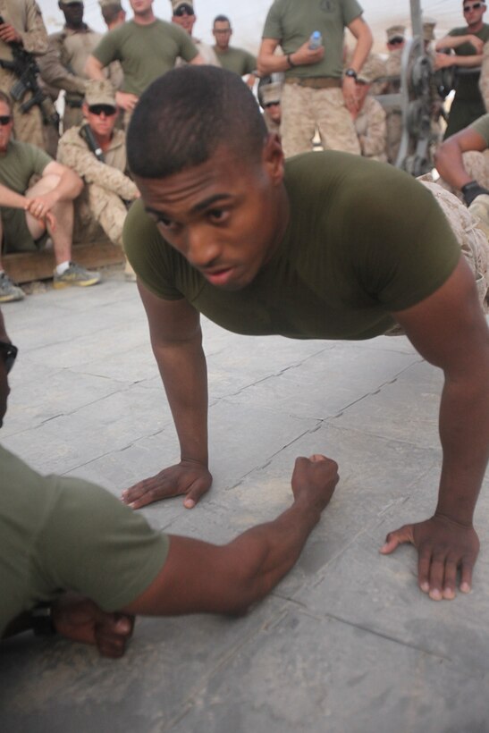 Lance Cpl. Jose Garcia, 22, an administrative clerk with Headquarters and Service Company, 2nd Battalion, 8th Marine Regiment, Regimental Combat Team 7, competes in push-up contest of the strong man competition held here July 23. "Our goal was to boost the morale of the Marines, while trying to keep them motivated and encourage physical fitness," said Sgt. Joseph Jennings, 27, the company police sergeant with Headquarters and Service Company. "Even if no one would have come out, we still would have had a good time."