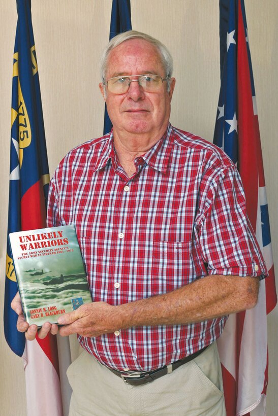 Jerry Laney poses with a book entitled “Unlikely Warriors The Army Security Agency’s Secret War In Vietnam 1961 - 1973,” which ‘highlights his and other soldiers gathering intelligence on behalf of the National Security Agency.