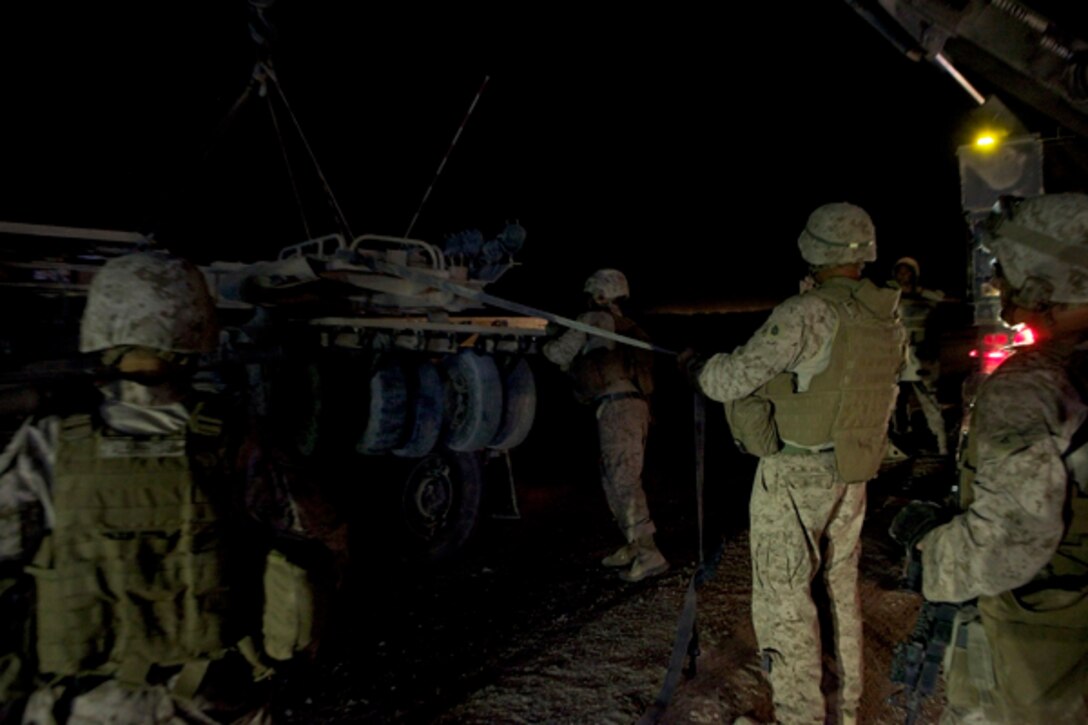 A crew of Marines with Combat Logistics Regiment 2, Regional Command (Southwest), work into the early morning hours to recover a downed mine roller near Camp Leatherneck, Afghanistan, July 26, 2013. The Marines cordoned off the area to provide security for the recovery team as they rushed to clear the road before it interrupted local traffic patterns. 