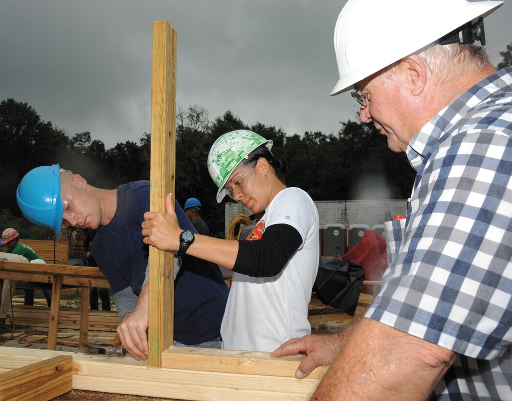 Under the direction of Jimmy Cross, construction manager, Flint River Habitat for Humanity, right, Staff Sgt. Juana DeLosSantos, center, and Sgt. Harold Paine, both with Marine Corps Logistics Command, build window framing for a Habitat for Humanity home near the Albany Southwest Georgia Regional Airport, Friday. They were among 16 Marines who volunteered their time to help construct a home for an Albany family. In addition to building window frames, the Marines helped measure and cut wood for the window frames and walls as well as helped set up the framework for the walls.