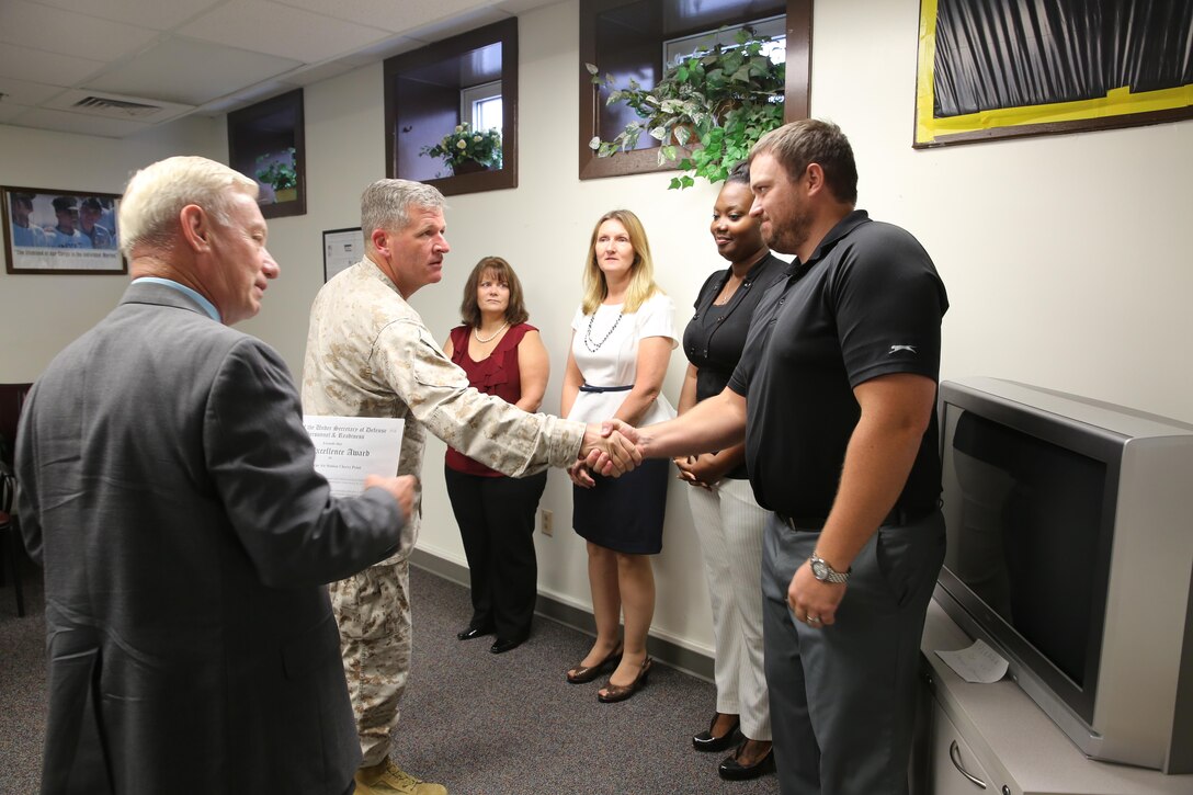 Col. Philip J. Zimmerman, commanding officer of Cherry Point, greets members of the DEERS and RAPIDS office during a ceremony Aug. 14.