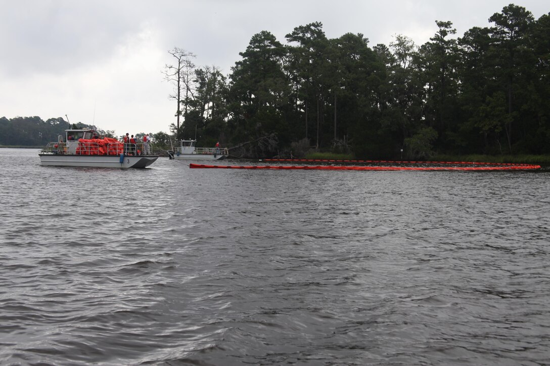 The Facility Response Team sets up a boom to contain a simulated oil spill on Slocum Creek Aug. 14 as a part of annual training.


