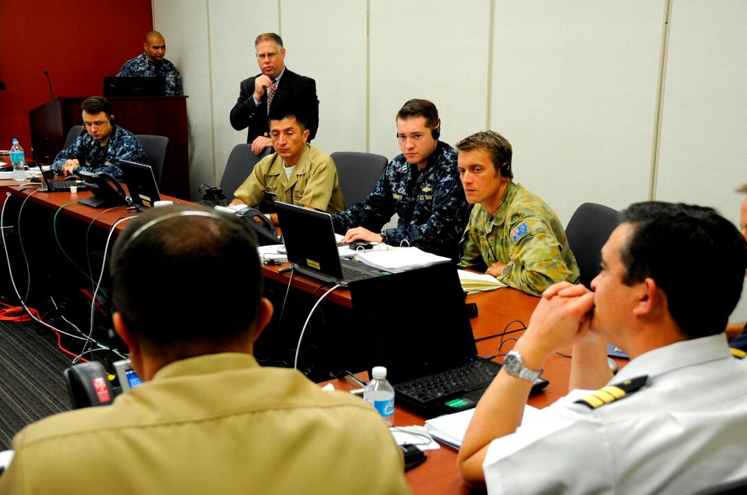 Australian Army Maj. Benjamin Watson, the assistant operations officer from the U.S. Marine Corps 15th Marine Expeditionary Unit, listens, through interrupter services, to an fellow PANAMAX 2013 participant during a discussion about defense strategies, August 15. Watson is participating in PANAMAX as a member of the Coalition Forces Maritime Component Command Cell. PANAMAX 2013 is an annual U.S. Southern Command-sponsored exercise series that focuses on ensuring the defense of the Panama Canal. PANAMAX 2013 develops and sustains relationships that improve the capacity of our emerging and enduring partners' security forces to achieve common desired goals, while fostering friendly cooperation and understanding among participating forces. PANAMAX 2013 is a multinational exercise that, this year, includes participants from Argentina, Belize, Brazil, Canada, Chile, Colombia, Costa Rica, Dominican Republic, Ecuador, El Salvador, France, Guatemala, Honduras, Mexico, Nicaragua, Panama, Paraguay, Peru, and the United States. (Official Marine Corps photo by SSgt. Earnest J. Barnes)